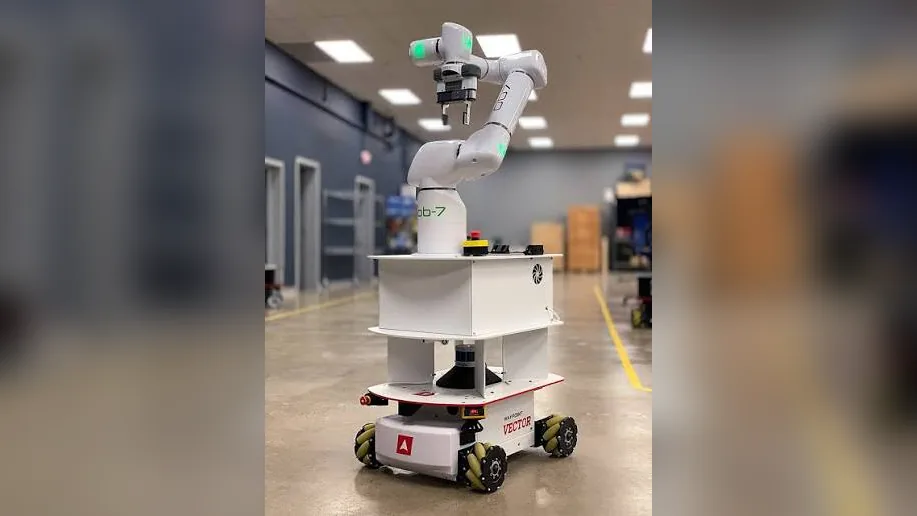 Mobile manipulator: collaborative robot arm mounted on an autonomous mobile robot base in a factory aisle